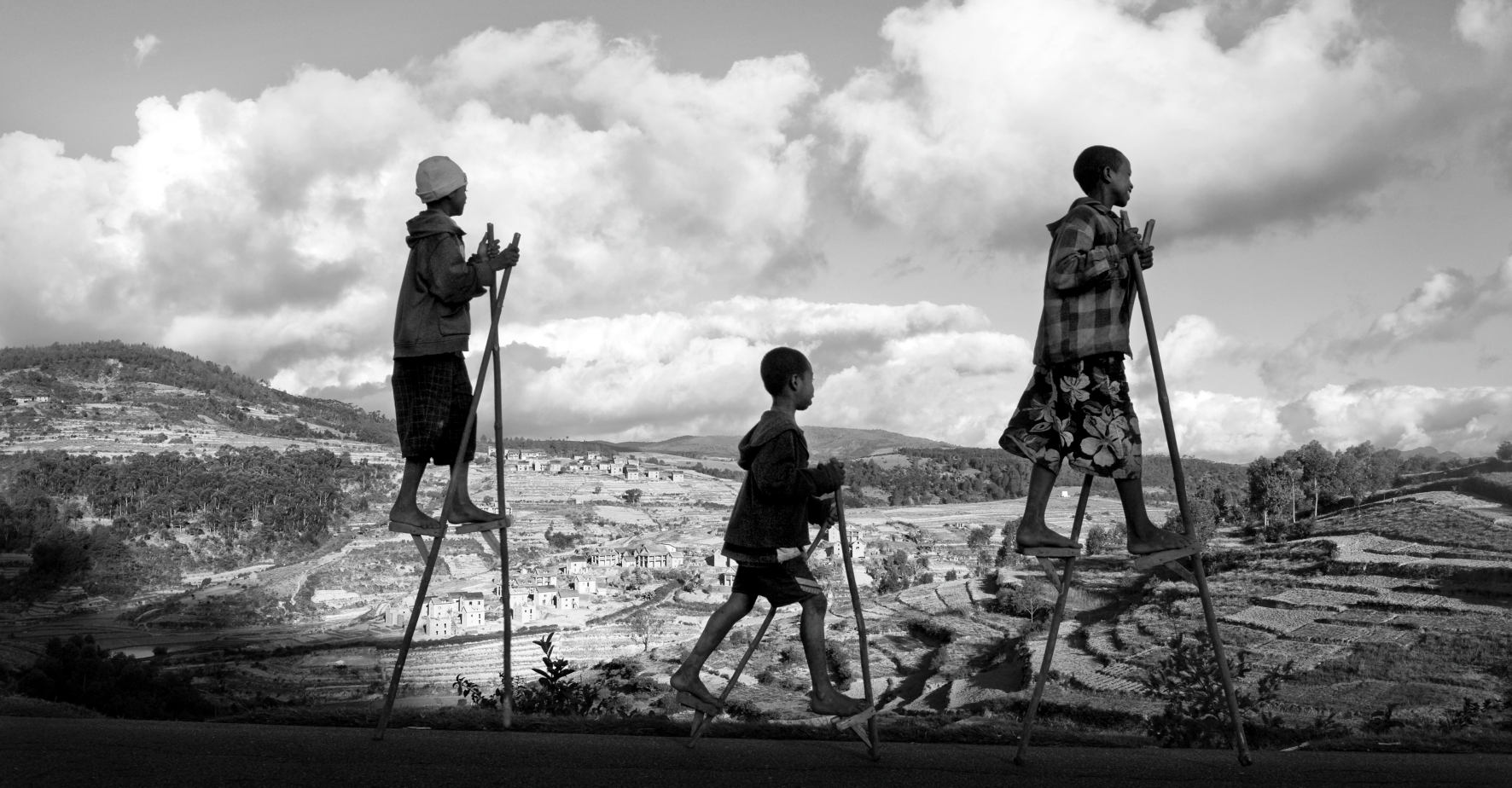 Des enfants de Madagascar, gardiens de zébus, sur des échasses